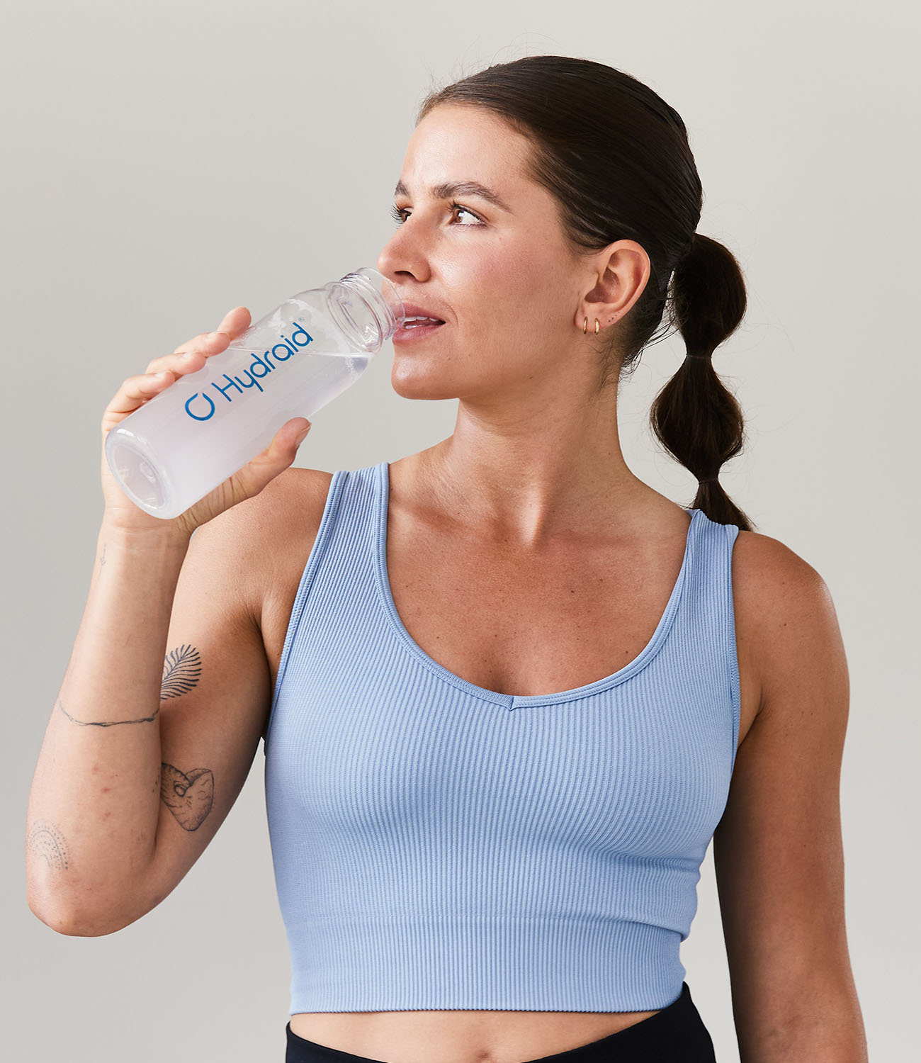Women trinking Hydration Helper® Lemon out of Hydraid® Bottle 